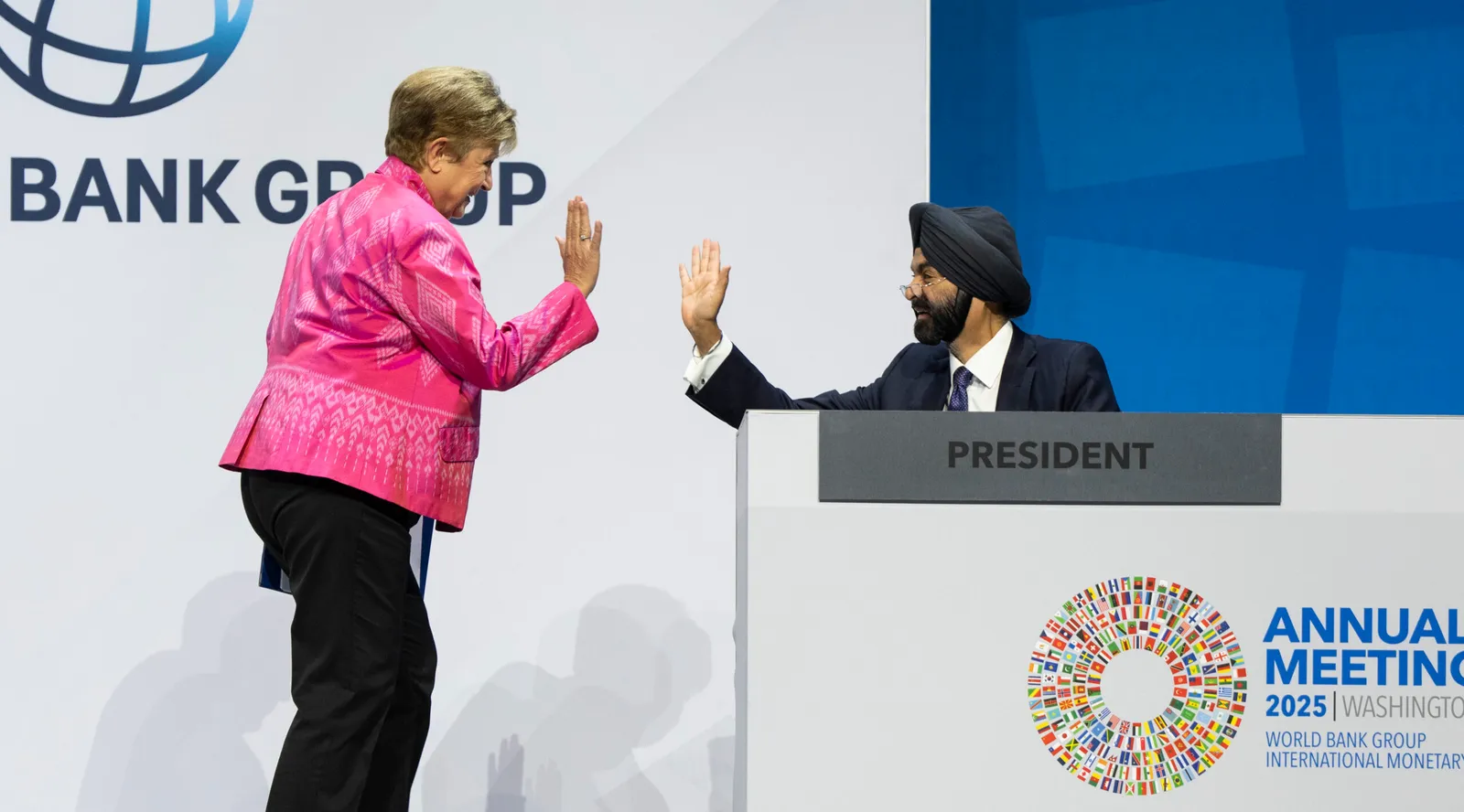 IMF Managing Director Kristalina Georgieva and World Bank President Ajay Banga high five on the dais at the Plenary Session of the 2025 Annual Meetings of the World Bank Group and International Monetary Fund in Washington, DC, on October 17, 2025.